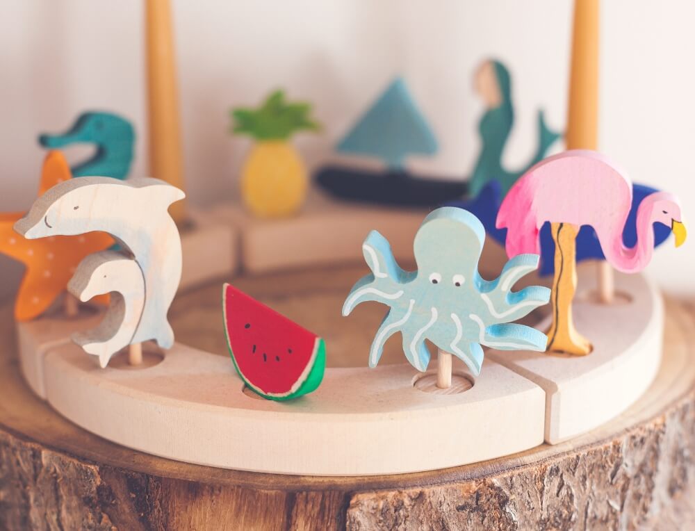 Colourful wooden animals and other Grimm's celebration ring figures for a Waldorf Birthday celebration - available in Australia form Oskar's Wooden Ark