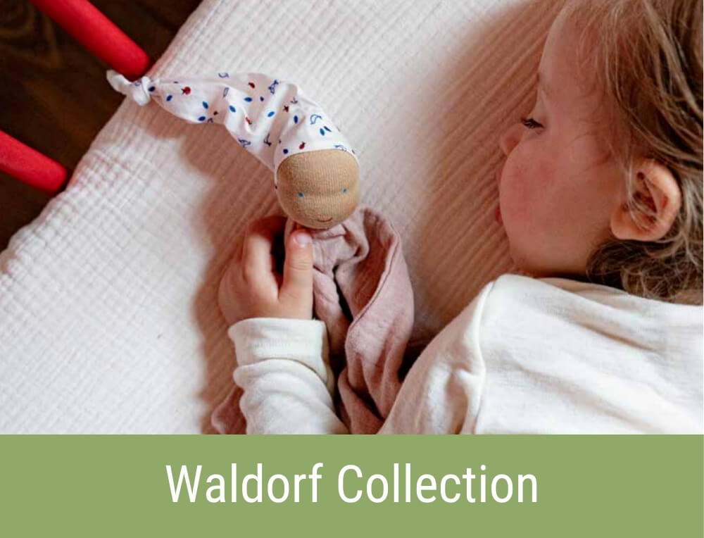 Baby snuggling with handcrafted Kathe Kruse Waldorf comforter toy from Oskar's Wooden Ark in Australia