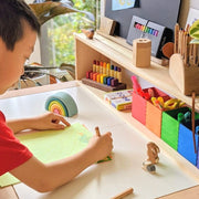 Boy writing with Lyra Pencil at School Desk, with other art materials, Learning Resources and School Work Essentials from Oskar's Wooden Ark in Australia