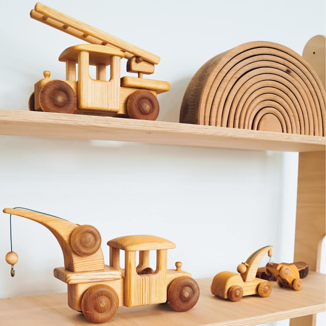 A toy shelf displaying Debresk Handmade Wooden Vehicles from Oskar's Wooden Ark in Australia