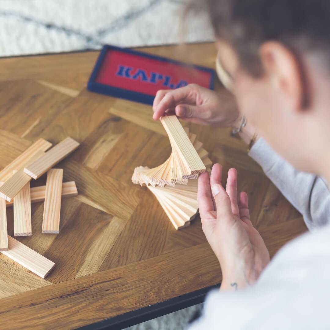 Adult enjoying mindful construction play with KAPLA wooden building planks from Oskar's Wooden Ark in Australia