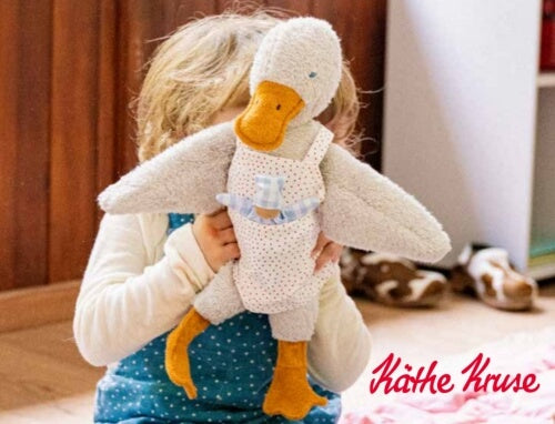 Child holding Kathe Kruse cuddly goose plush soft toy from Oskar's Wooden Ark in Australia