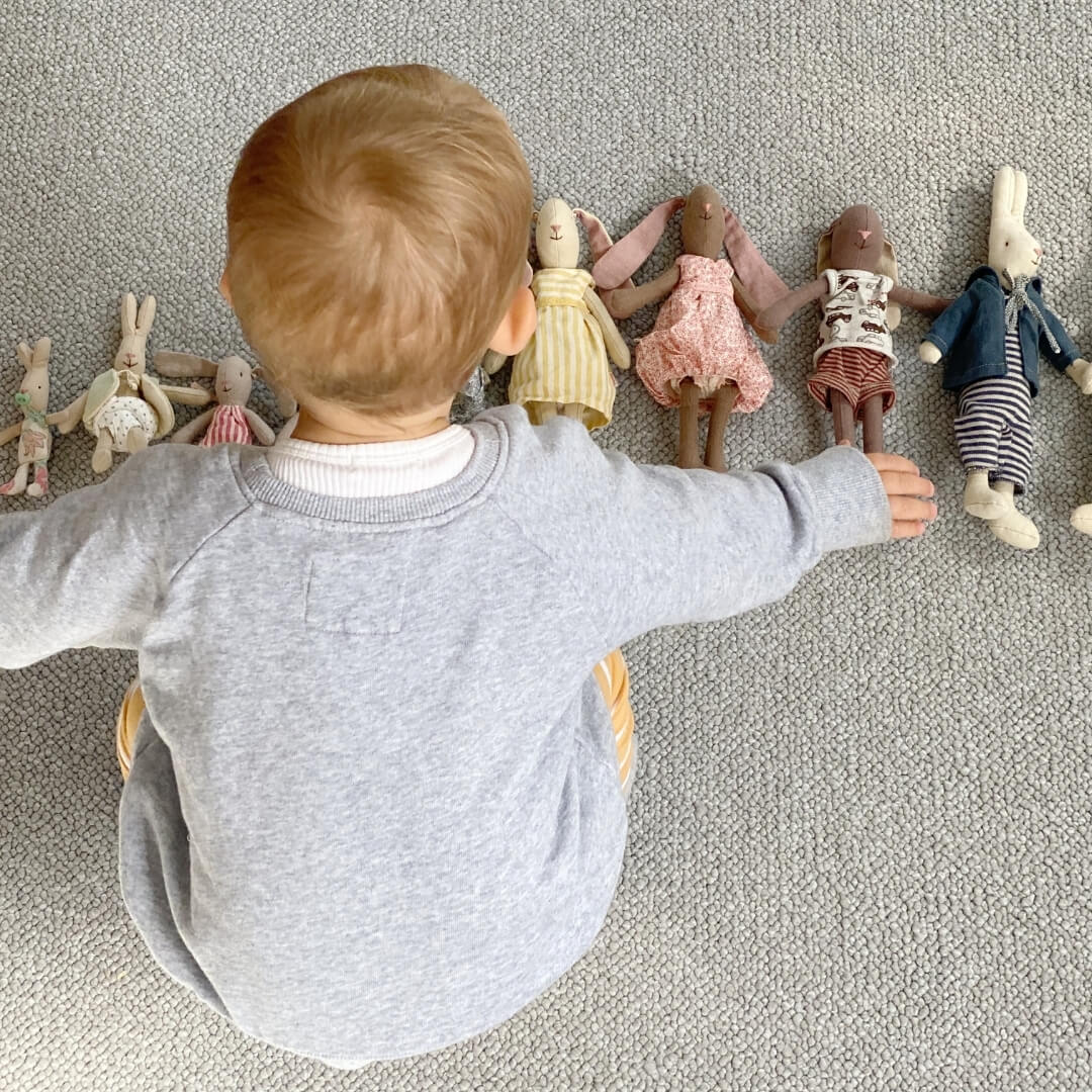 Child playing with Maileg Rabbits and Bunnies, arranged in size order, at Oskar's Wooden Ark in Australia