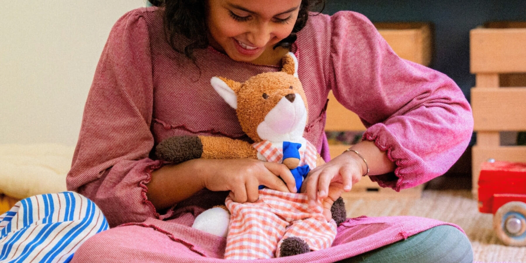 Child playing with Kathe Kruse cuddly soft toy fox at Oskar's Wooden Ark in Australia