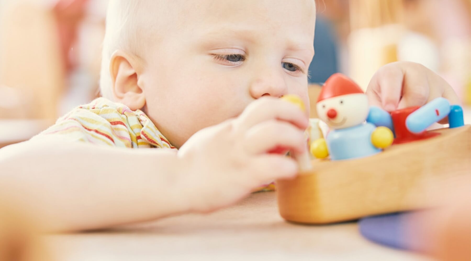 Toddler playing with Pfingstweid wooden toy boat and figure at Oskar's Wooden Ark in Australia