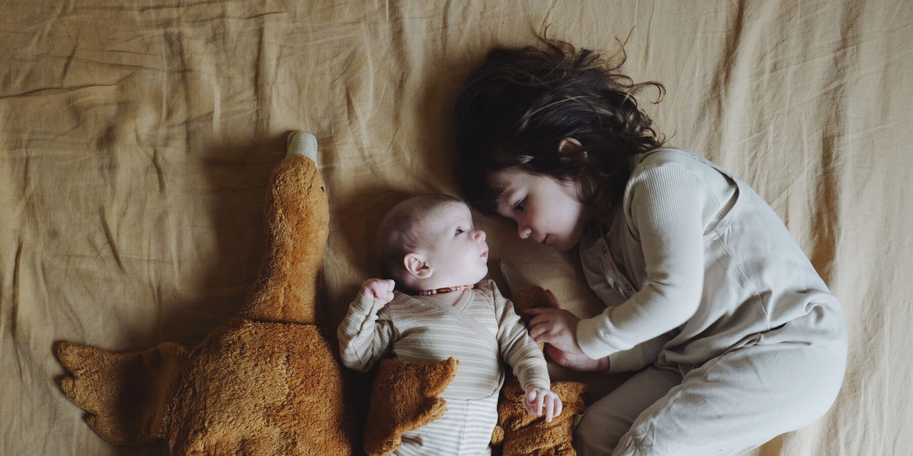 Child and baby snuggling with Limited Edition Rust Goose SENGER Natural Soft Toy from Oskar's Wooden Ark in Australia