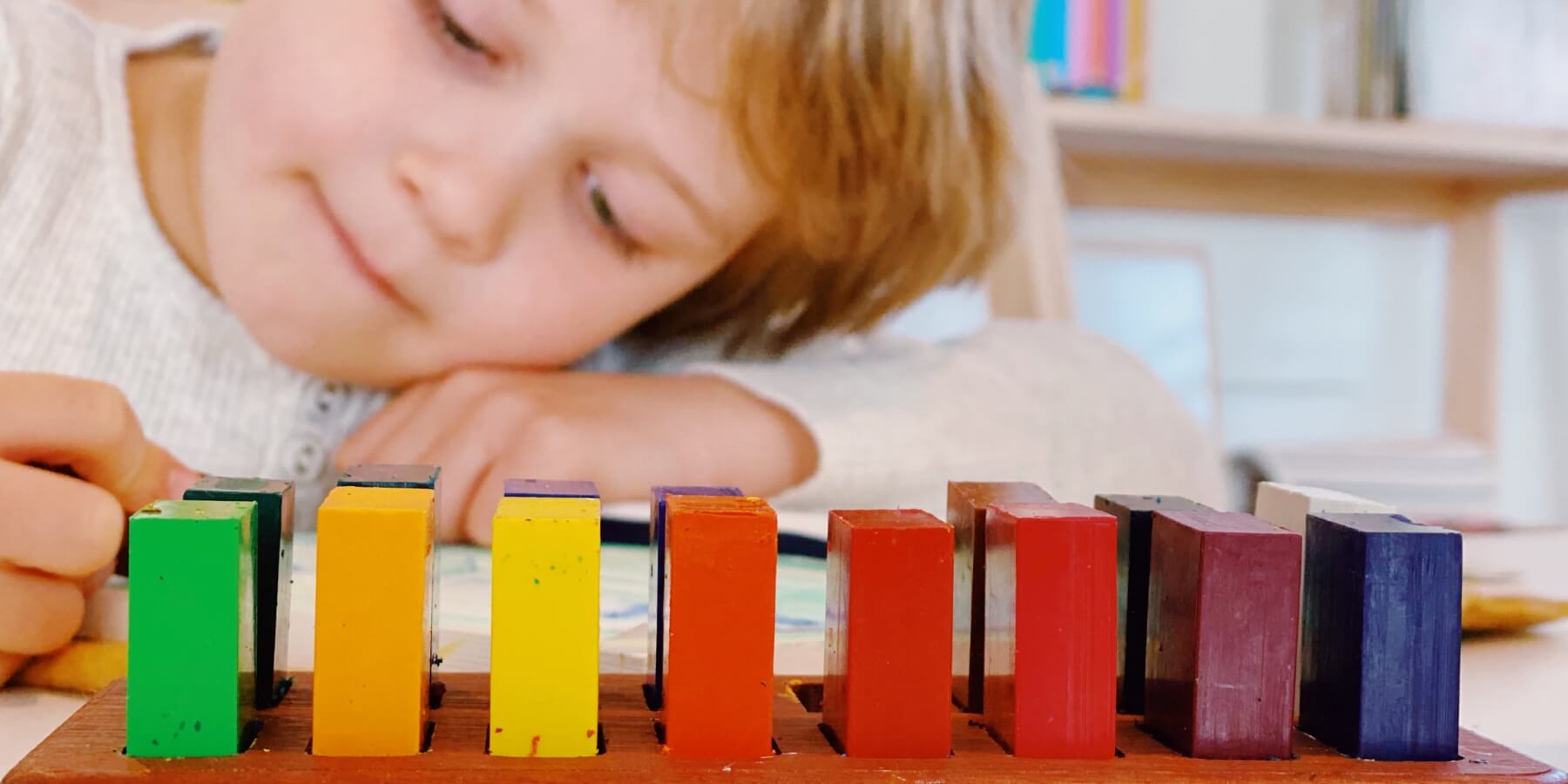 Child drawing in school lesson book with STOCKMAR block crayons at Oskar's Wooden Ark in Australia