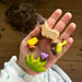 BumbuToys Handcrafted Wooden Farm Animal Chick and other toys on a person's hand from Australia