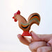 BumbuToys Handcrafted Wooden Farm Animal Rooster from Australia being held by an adult person's hand