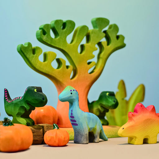 BumbuToys Handcrafted Wooden Baby Dinosaur Brontosaurus from Australia with other baby dinos in a prehistoric small-world playscape
