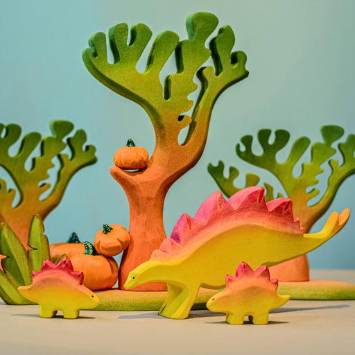 BumbuToys Handcrafted Wooden Dinosaur Stegosaurus Family from Australia in a small-world play setting