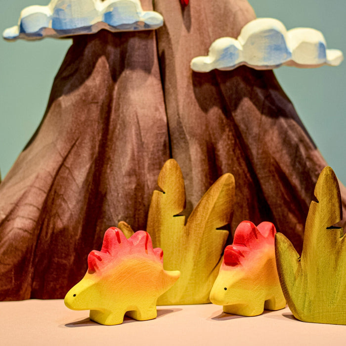 BumbuToys Handcrafted Wooden Dinosaur Stegosaurus Babies from Australia in a small-world play setting