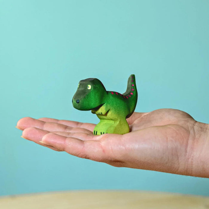 BumbuToys Handcrafted Wooden Dinosaur Baby T-Rex from Australia on an adult person's hand