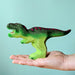 BumbuToys Handcrafted Wooden Dinosaur T Rex from Australia on an adult person's hand