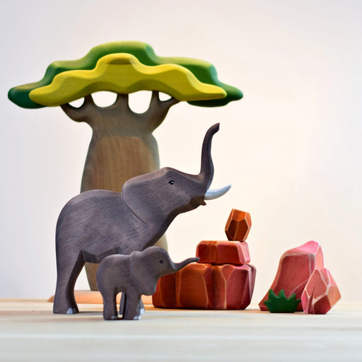 BumbuToys Handcrafted Wooden Landscape Savanna Rocks Set of 5 from Australia in a small-world play setting