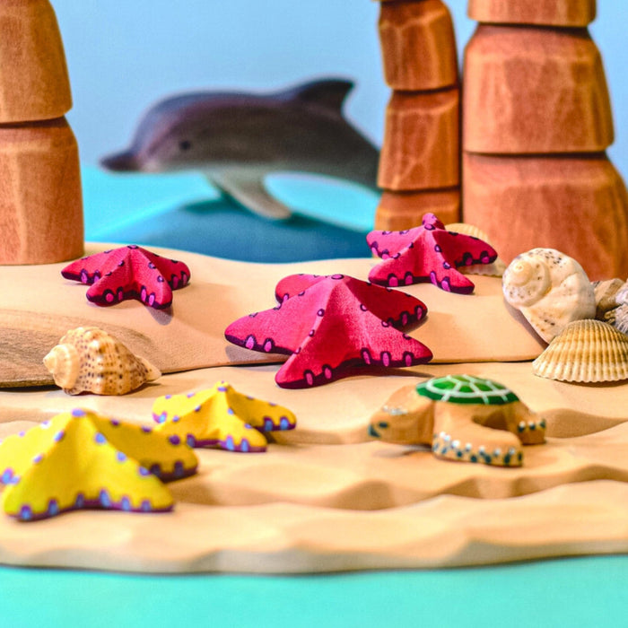 BumbuToys Handcrafted Wooden Starfish Set in Red from Australia in a small-world play setting