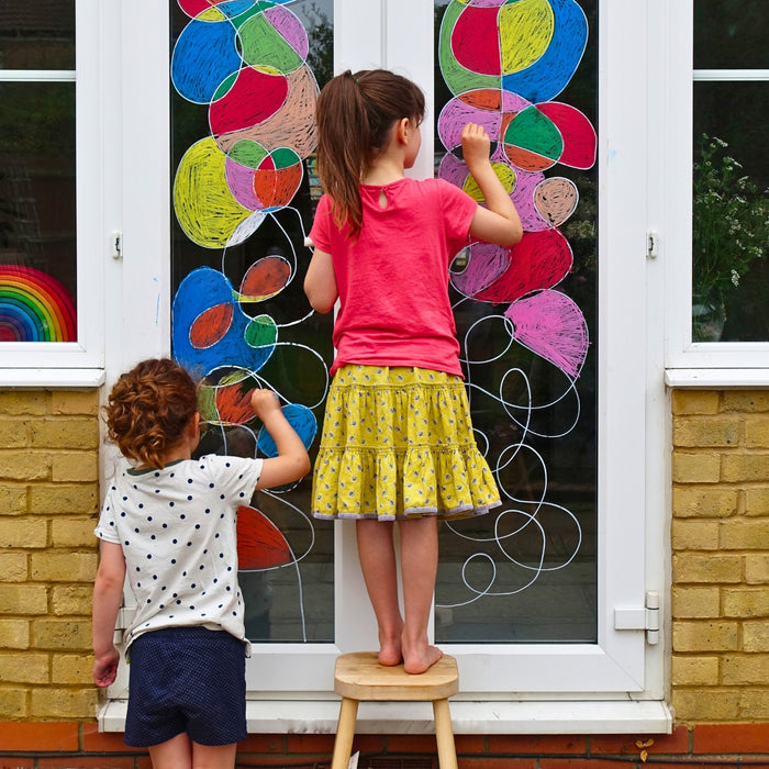 Children drawing on a window using Kitpas removeable rice bran wax crayons from Australia