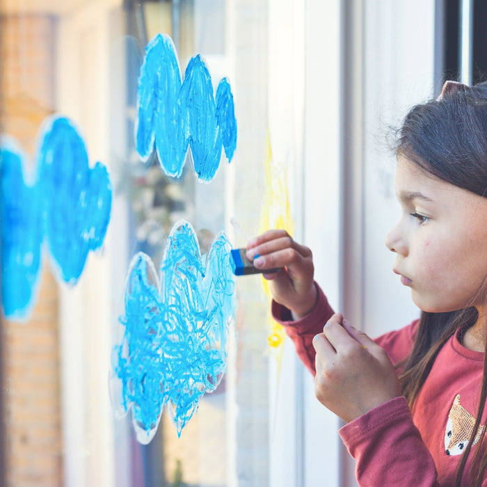 Child drawing on a window using Kitpas removeable rice bran wax crayons from Australia